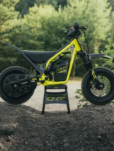 Triumph TXP-12 Elektromotorrad für Kinder im Gelände, Seitenansicht auf einem Erdwall
