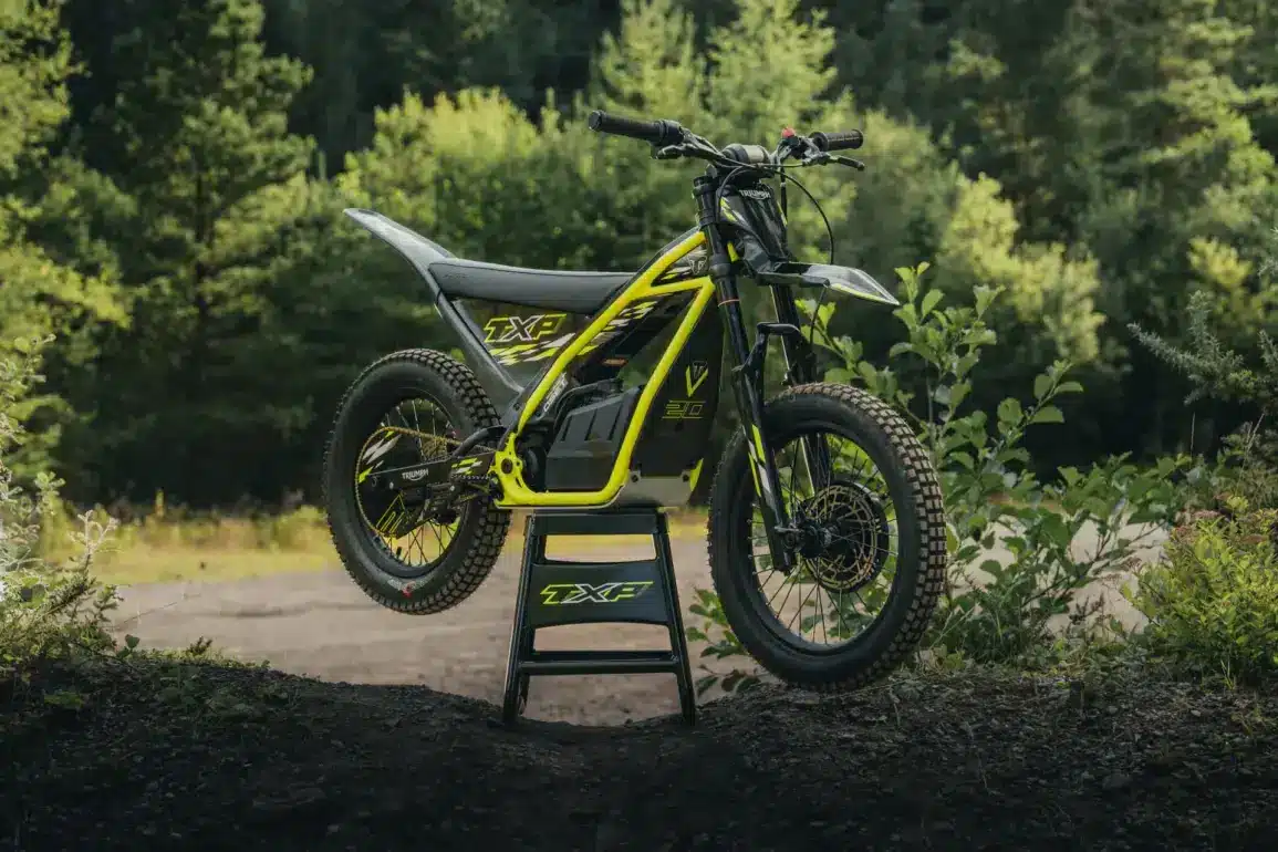 Triumph TXP-20 Elektromotorrad für Kinder im Offroad-Gelände auf einem Ständer.
