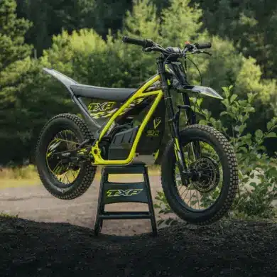 Triumph TXP-20 Elektromotorrad für Kinder im Offroad-Gelände auf einem Ständer.