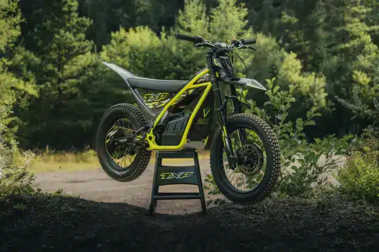 Triumph TXP-20 Elektromotorrad für Kinder im Offroad-Gelände auf einem Ständer.
