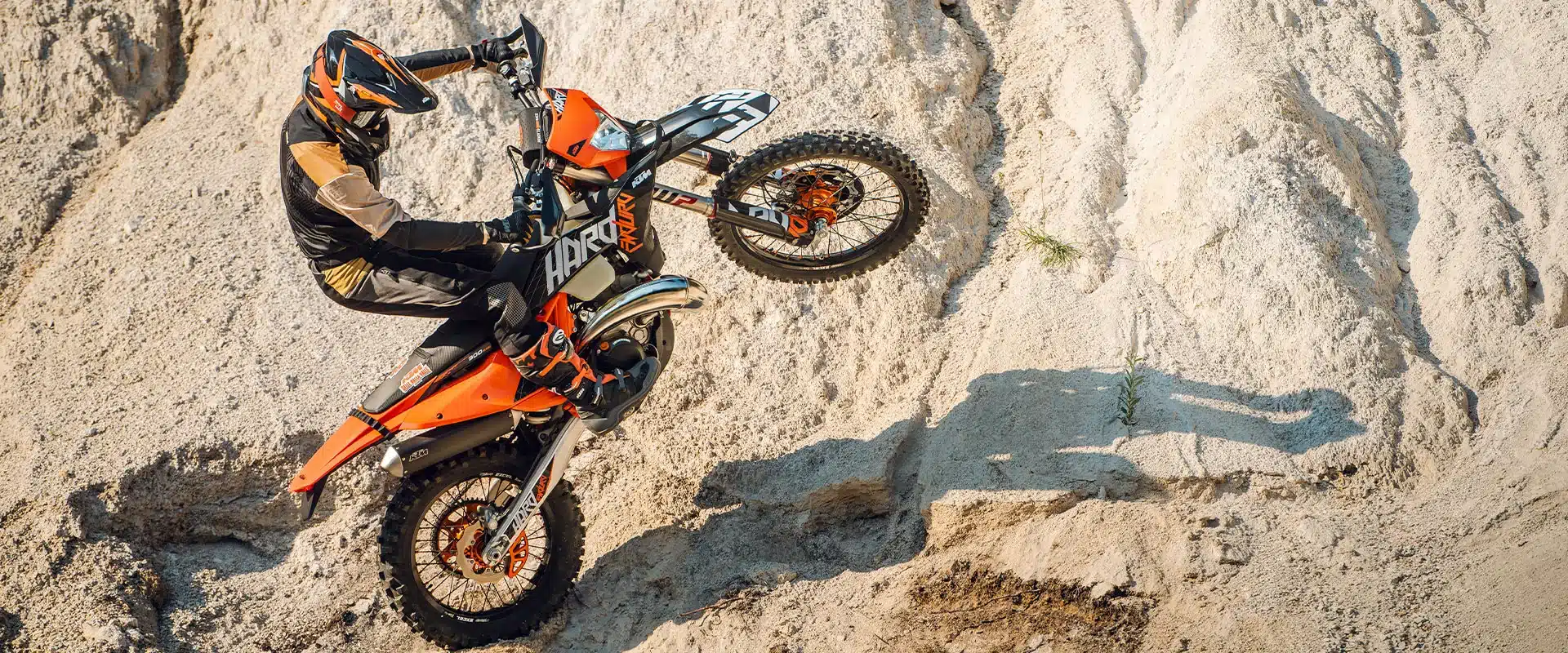 Fahrer bezwingt mit einer KTM 300 EXC HARDENDURO eine steile, steinige Auffahrt im Gelände.