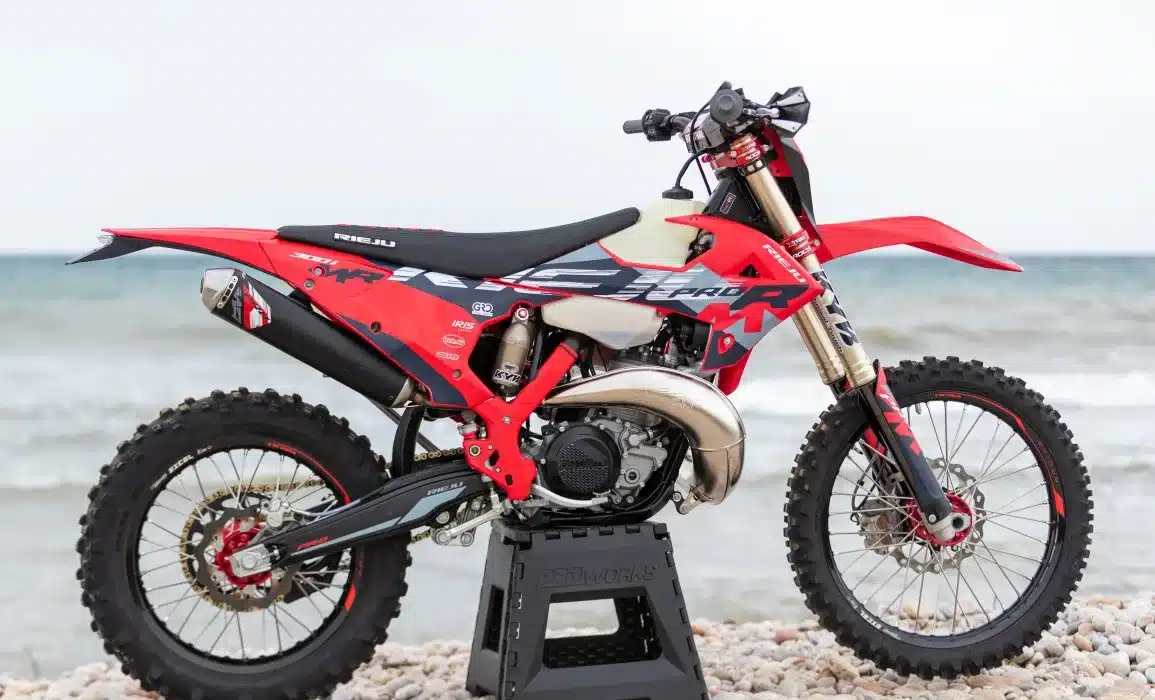 Rieju MR 300i PRO 2027 Enduro-Motorrad in Rot und Schwarz seitlich am Meeresufer