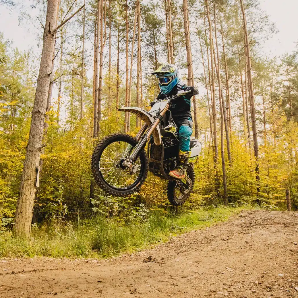 Motocross-Fahrer auf einer HVR 85PRO beim Sprung auf einer Offroad-Strecke im Wald.