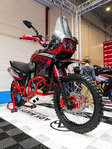 Honda XL650V Transalp als Adventure-Umbau mit Rallye-Front, Motorschutz und Navigation Tower auf einer Ausstellungsfläche.