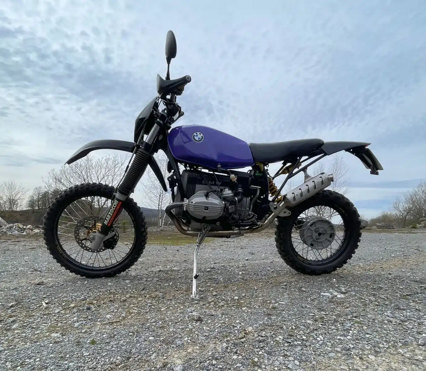 SWT-SPORTS EnduroBoxer Nr. 150, eine umgebaute BMW R 80 G/S mit KTM-Anbauteilen und optimiertem Rahmen, steht auf losem Untergrund.
