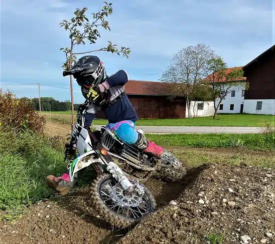 Kind fährt HVR 65PRO Elektromotorrad im Gelände