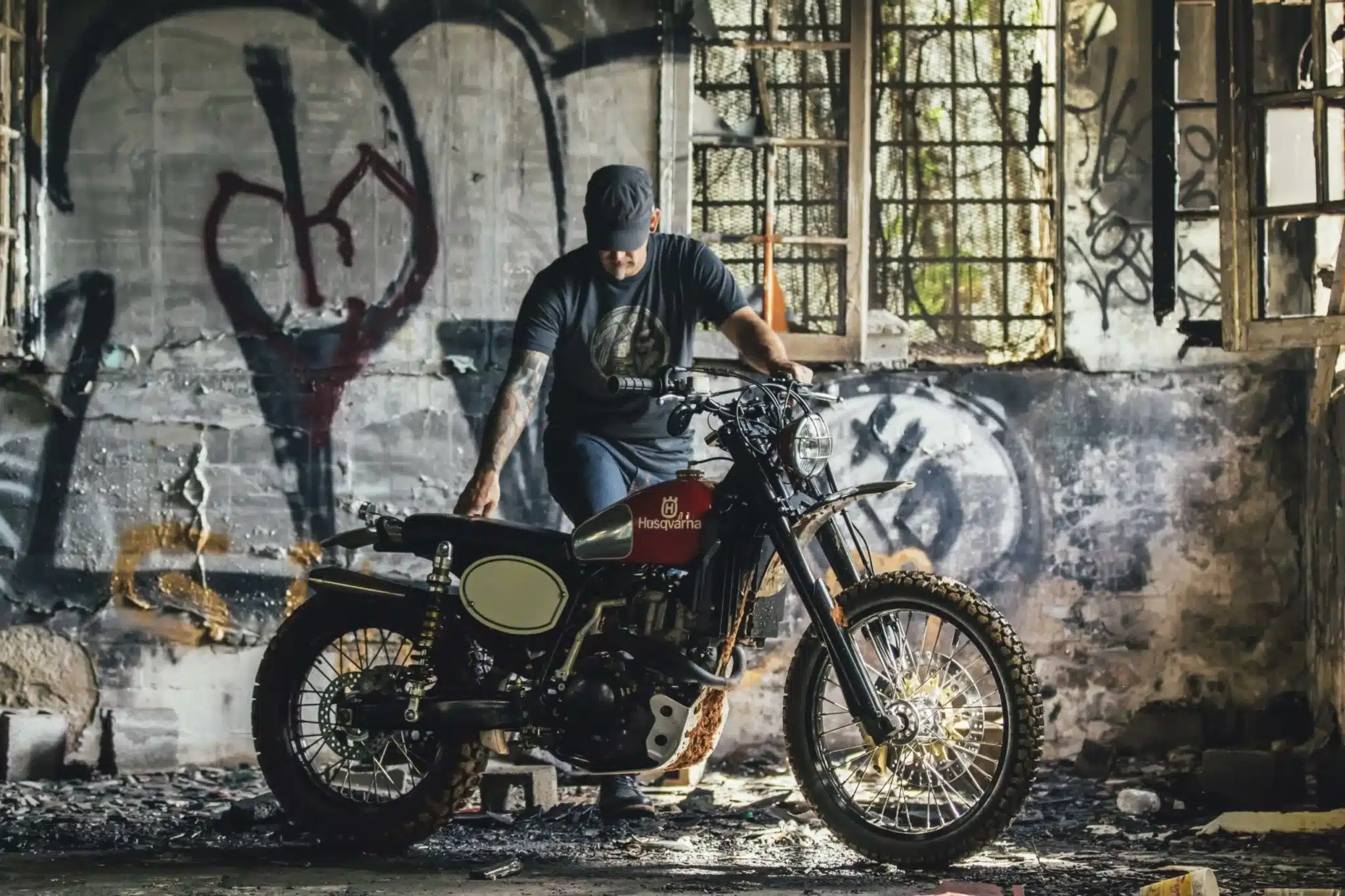 Motorrad-Umbau einer älteren Husqvarna mit Offroad-Reifen, abgelichtet in einer verlassenen Halle