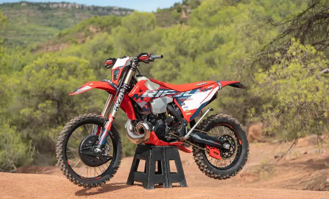 Rieju MR 300 i Hard Enduro 2027 auf einem Ständer in einer natürlichen Offroad-Umgebung, seitliche Ansicht.