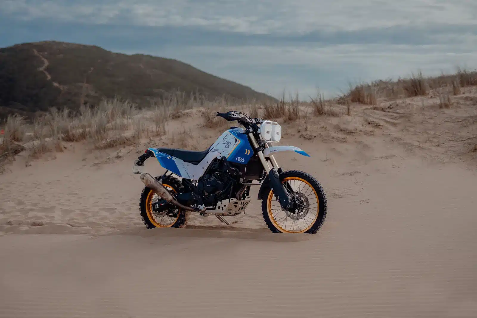 Yamaha Ténéré mit Baja-Umbaukit, Doppelscheinwerfer und blauen Verkleidungen in der Wüste