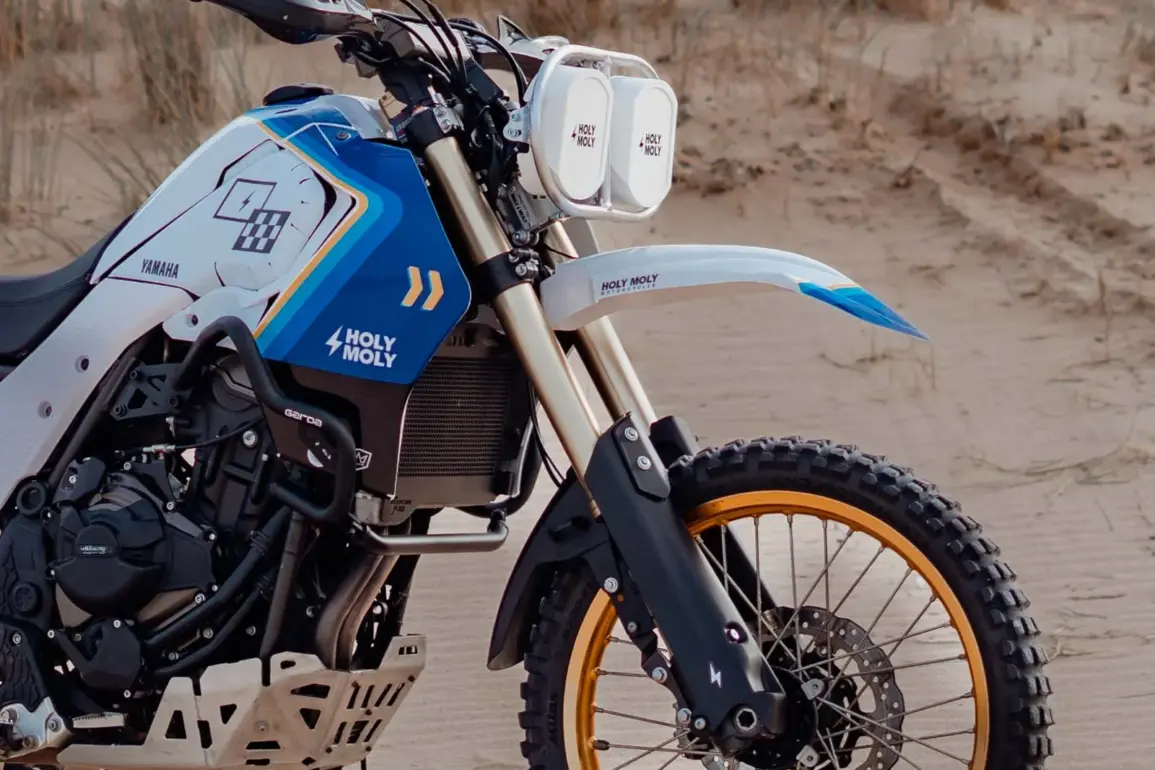 Seitenansicht einer Yamaha Ténéré 700 mit montiertem Baja-Umbaukit und Doppel-Scheinwerfern in einer Sandlandschaft