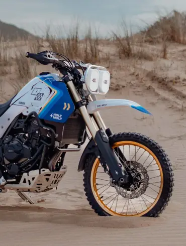 Seitenansicht einer Yamaha Ténéré 700 mit montiertem Baja-Umbaukit und Doppel-Scheinwerfern in einer Sandlandschaft