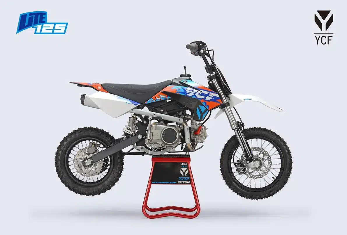 Seitenansicht der YCF Lite 125, einem leichten 125ccm-Offroad-Motorrad mit blau-oranger Verkleidung auf Montageständer.