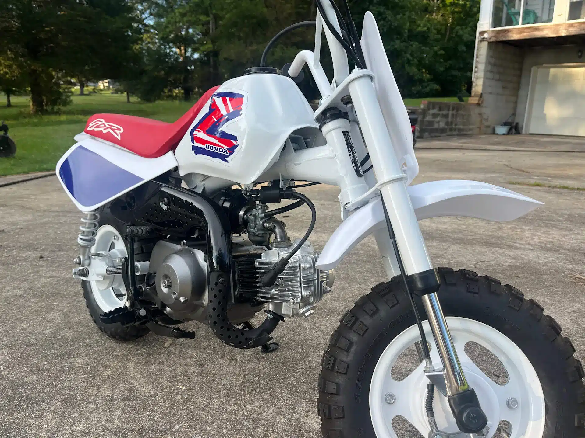 Nahaufnahme einer 1995 Honda Z50R mit weißem Fahrwerk und roter Sitzbank