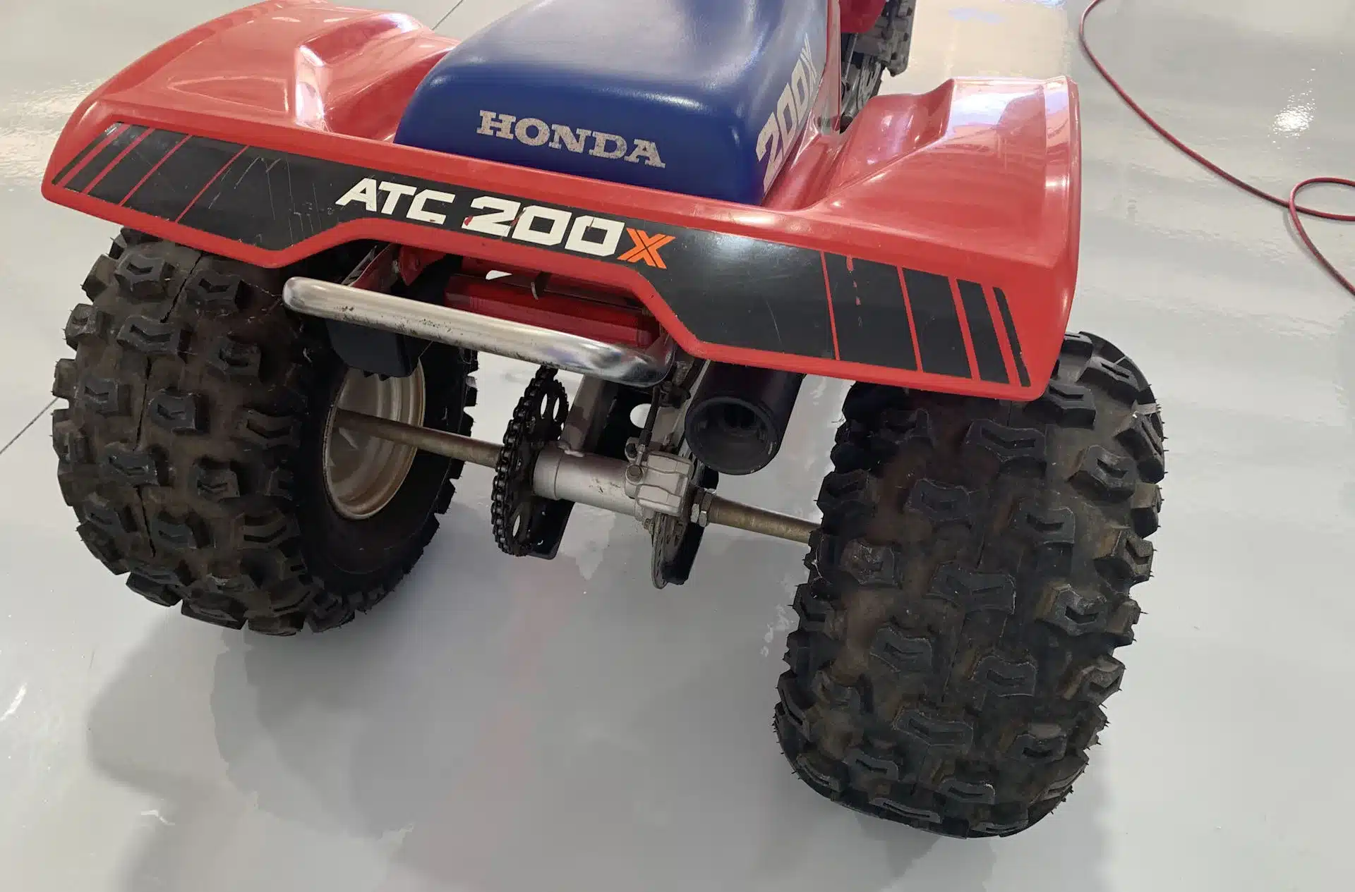 Heckansicht der klassischen Honda ATC 200X mit blauer Sitzbank und grobstolligen Offroad-Reifen