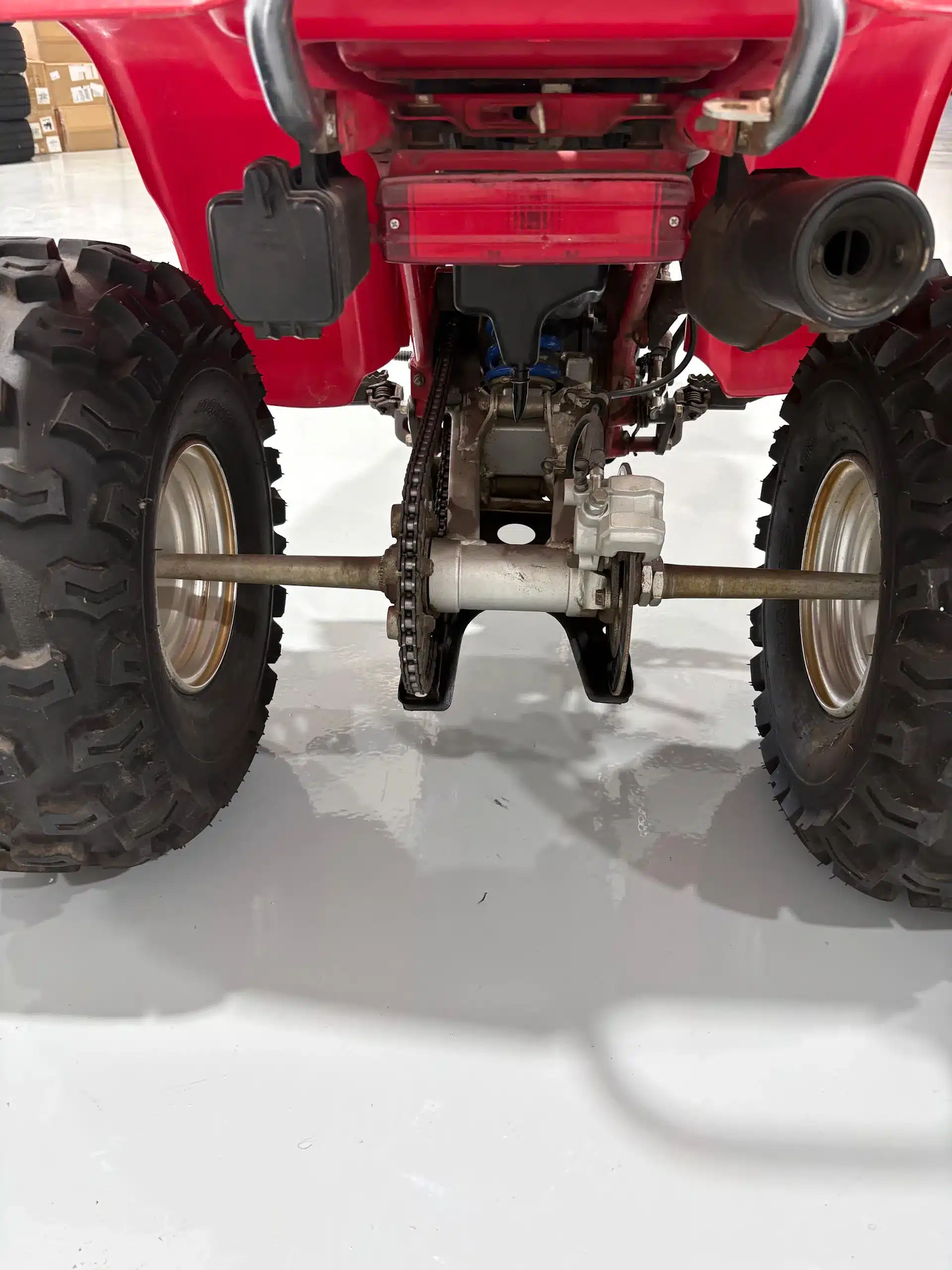 Detailansicht der hinteren Achse mit Kette und Stollenreifen der Honda ATC 200X