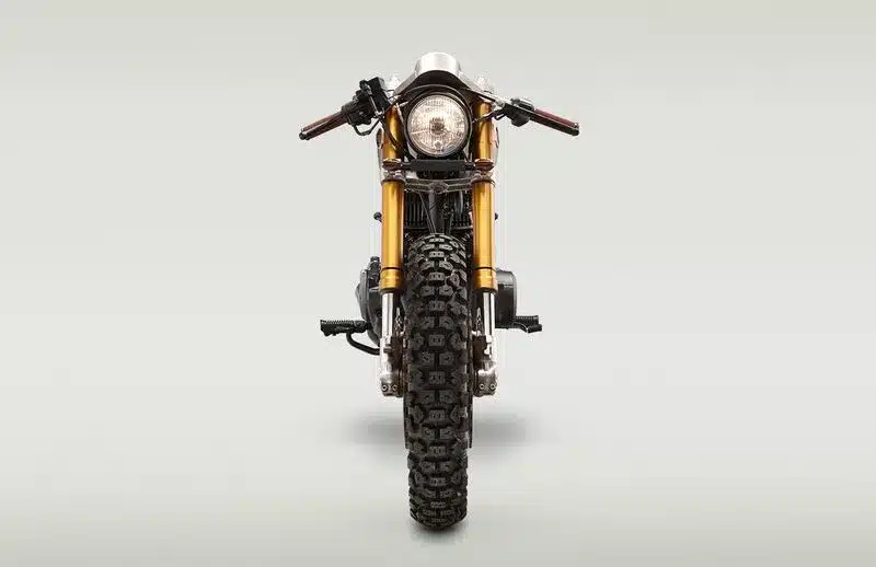 Frontale Ansicht der individuell umgebauten Honda CB450T Le Renard mit groben Dual-Sport-Reifen und goldenen Gabelholmen