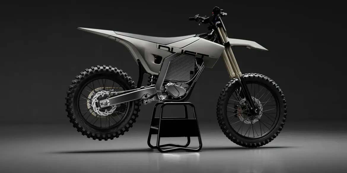 Elektrisches Dirtbike von Dust Moto auf einem Ständer vor dunklem Hintergrund.