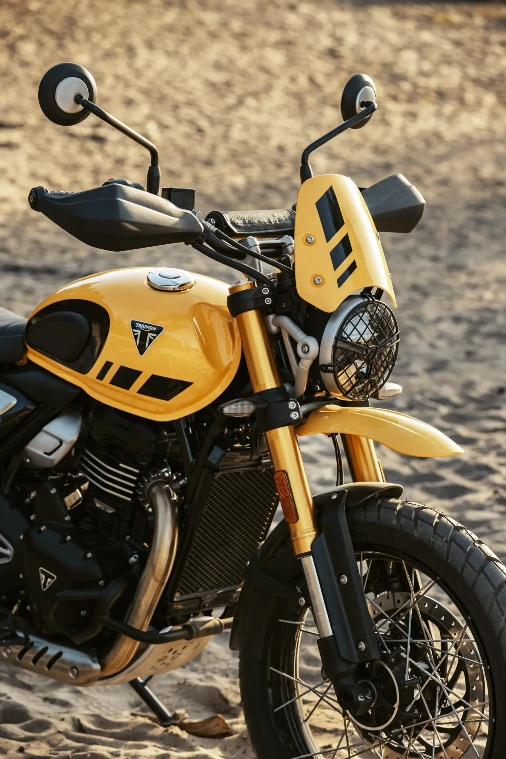 Triumph Scrambler 400 XC in Racing Yellow – Nahaufnahme mit Flyscreen, Speichenrad und Schutzausstattung.