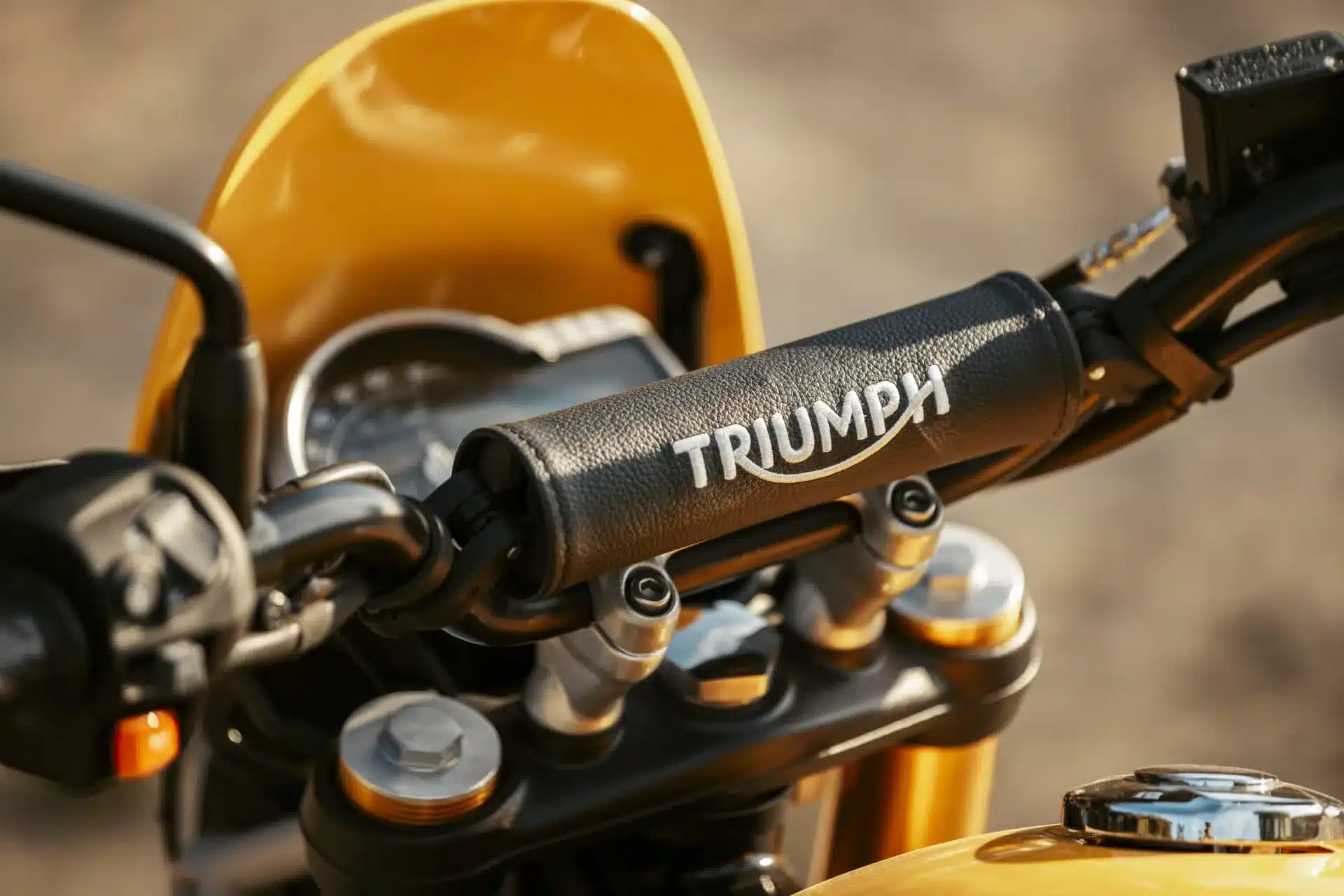 Lenker, Cockpit und Flyscreen einer Triumph Scrambler 400 XC in Gelb aus der Nähe fotografiert.