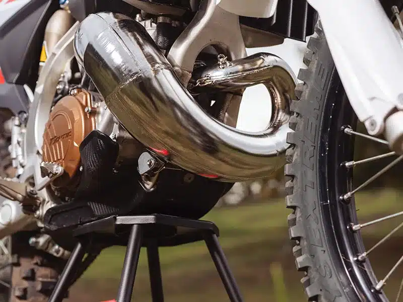 Detailaufnahme vom Motorbereich und Auspuff einer Fantic XE 300 Enduro im Gelände