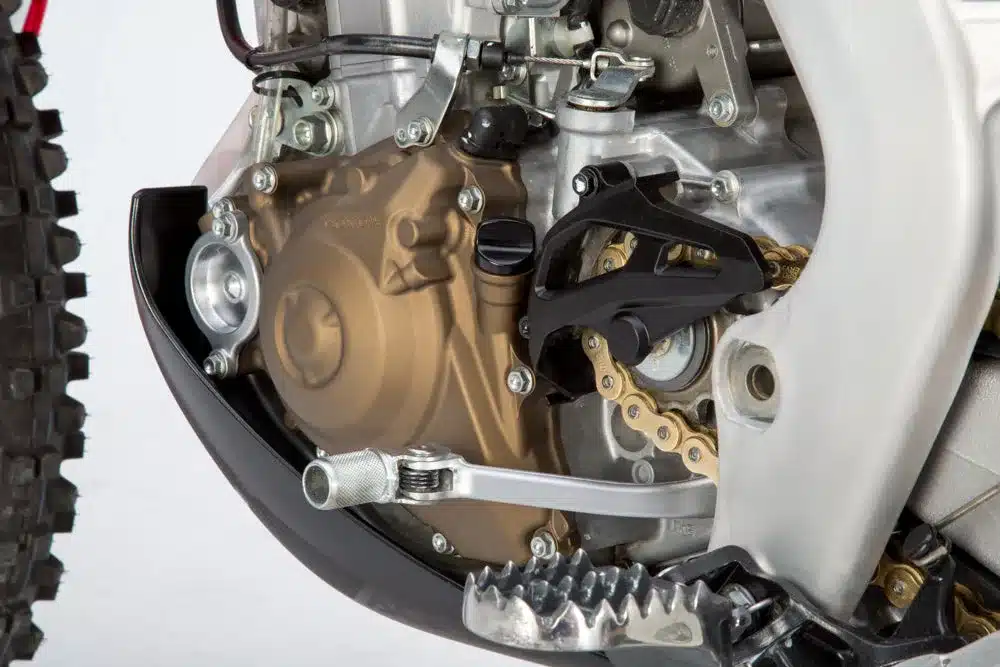 Nahaufnahme des Motorgehäuses, Motorschutzes und der Kettenführung einer Honda CRF450RX Enduro-Umbau.