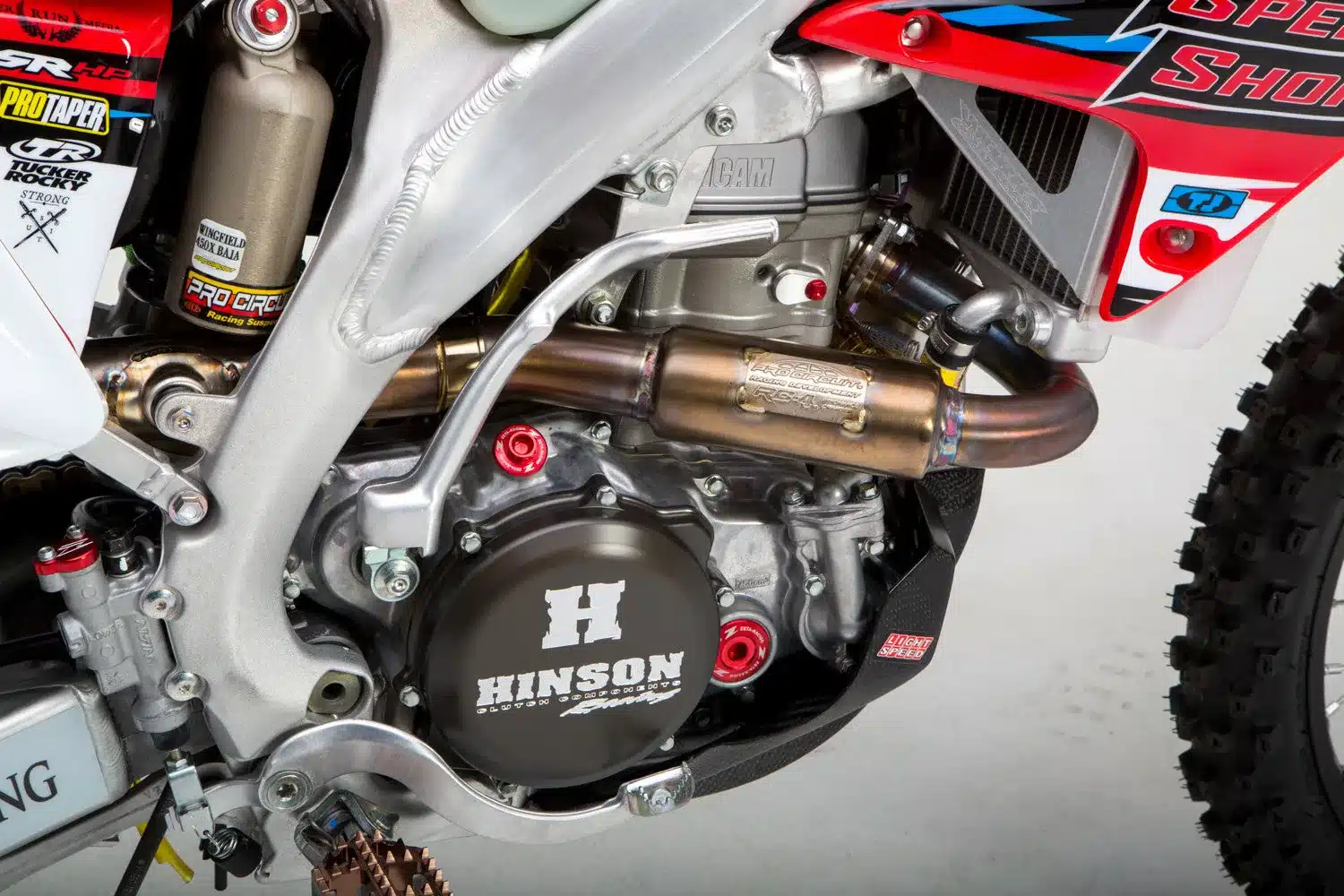 Nahaufnahme des Motors einer Honda CRF450X Baja 1000 Racer mit Pro Circuit T-5 Auspuff, Hinson Kupplungsdeckel und Fahrwerksdetails
